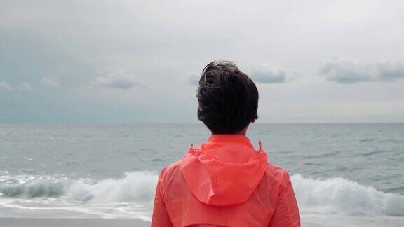 一个女人的肖像望着大海风吹过她的头发坚强的女性是站在海崖边望着海景地平线女人看着暴风雨的海洋