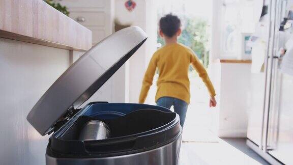 男孩在家把垃圾分类放进厨房垃圾桶