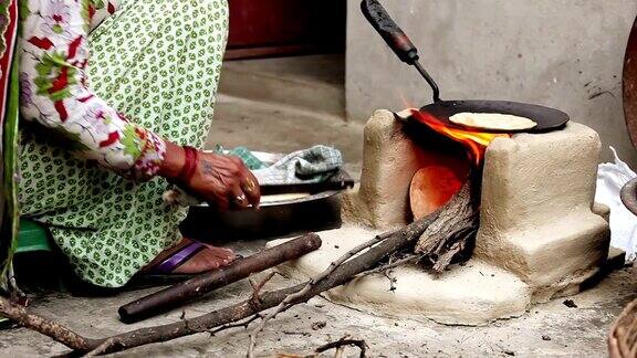 妇女在泥炉上做饭