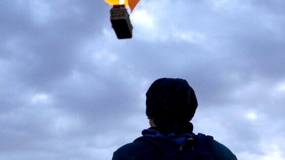 一名年轻人正在卡帕多西亚的戈雷米上空观看热气球