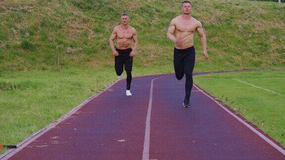 两个赤裸上身的男人一起在体育场跑步
