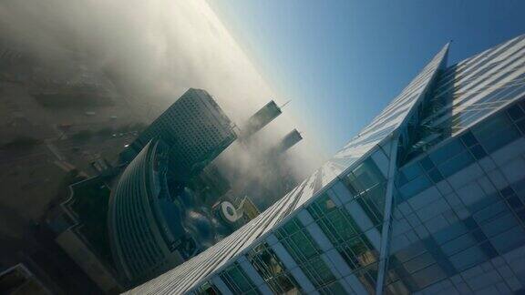 第一人称无人机飞行观看阳光明媚的城市景观在白天与高大的玻璃摩天大楼