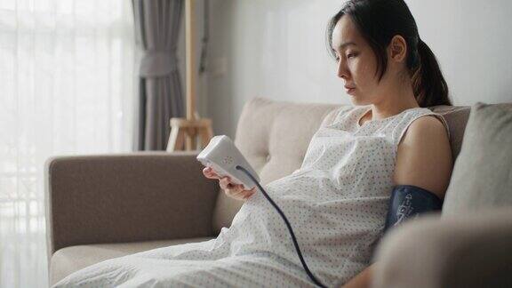 年轻的孕妇用数字测量仪器测量血压