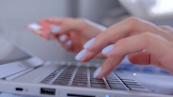 网上购物女人的手用笔记本电脑键盘和信用卡进行