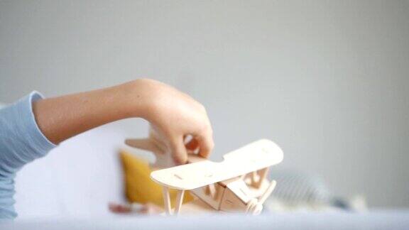 男孩的手玩木制飞机玩具模型的慢镜头老式运输玩具概念视频
