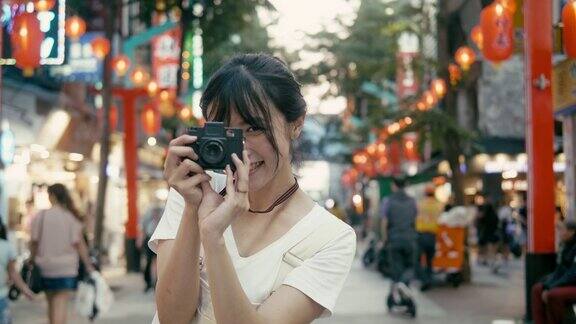 台湾千禧一代女性在西门町购物区用复古相机拍照(慢镜头)
