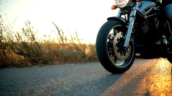 日落时分摩托车手在空旷的路上骑着摩托车