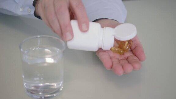 黄色胶囊-3脂肪酸倒入女性手掌从玻璃杯中饮用健康饮食和增强免疫系统