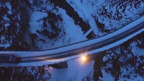 夜晚驶过阿尔卑斯山脉高架桥的列车航拍