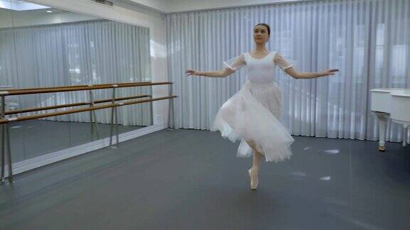 一个穿着白色芭蕾舞短裙和尖头鞋的芭蕾舞女演员在芭蕾舞室里旋转