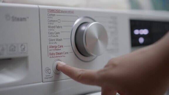 特写的人的手指按下按钮关闭洗衣机
