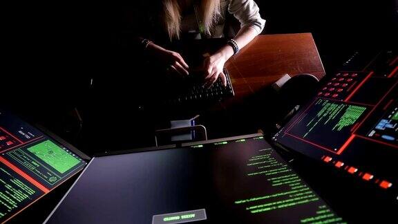 女人用手敲电脑代码黑屋子里的电脑工作中的黑客程序员