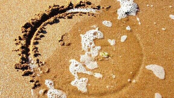 悲伤的脸画在沙子里被海水冲走