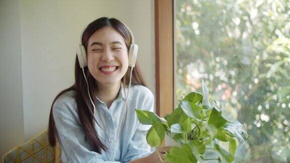 微笑的亚洲妇女拿着一个小植物