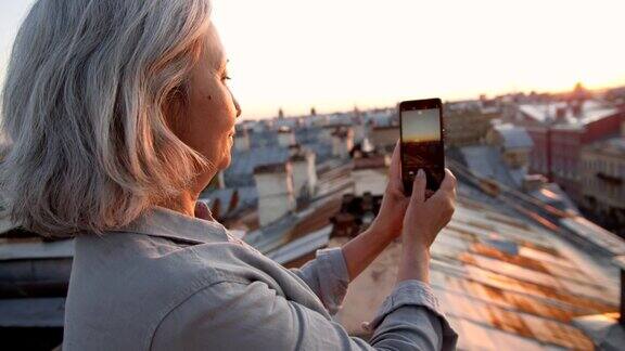 白发女游客在屋顶上拍照