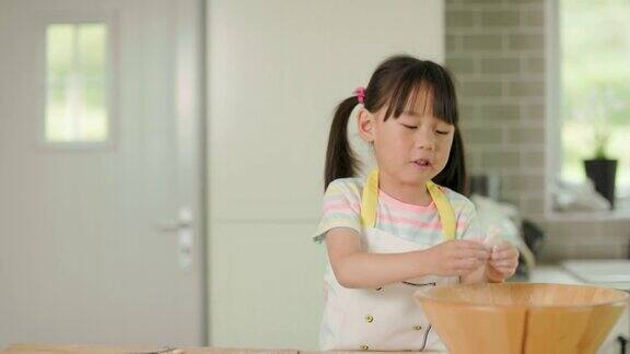 一个小女孩在家里的厨房里用面粉玩面团