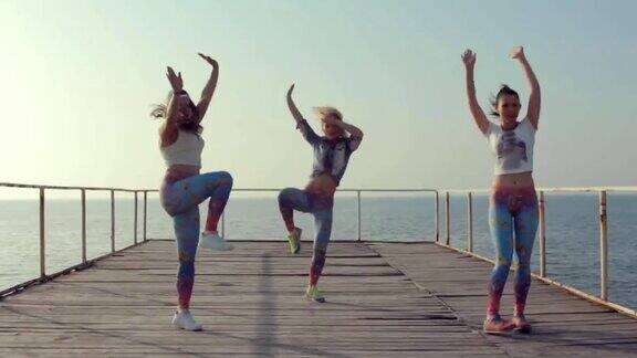 年轻姑娘们在海边的码头上跳现代舞