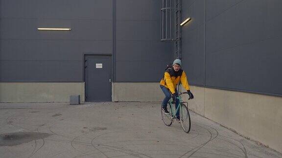 穿着黄色夹克的负责任的白人青年用自行车作为交通工具