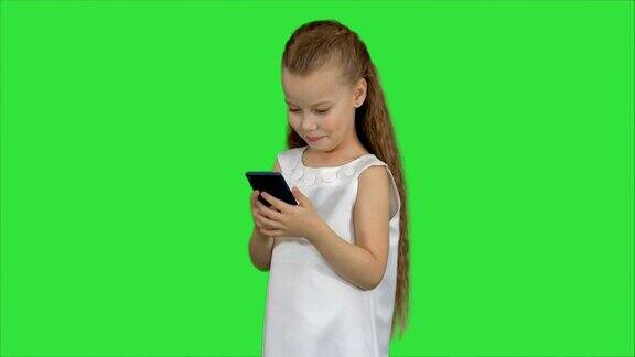 小女孩在绿屏上用智能手机色度键