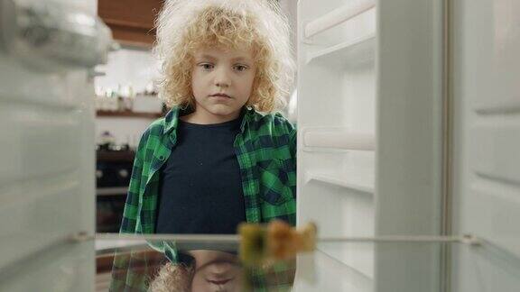 沮丧的男孩看着空荡荡的冰箱