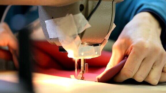 在缝纫机上缝制皮革的手工艺妇女的手