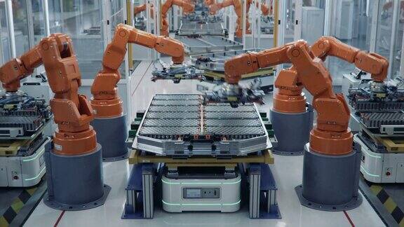 橙色机械臂装配线上汽车工业用电动汽车电池组的延时拍摄自动化电动汽车智能工厂配备机械臂的电池生产线