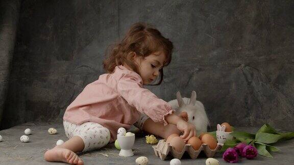 小女孩抚摸着可爱的小白兔小女孩和小兔子一起玩复活节兔子用五彩缤纷的复活节兔子蛋漂亮的复活节兔子用兔子作为复活节节日复活节兔子复活节