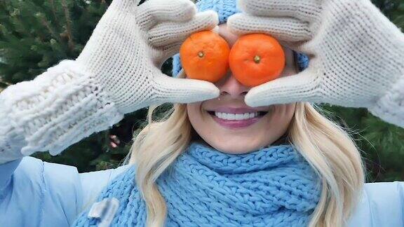 有趣的女孩用两个橘子代替眼睛