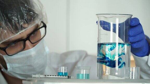 科学家戴着口罩和医用手套在实验室中注入化学研究将试剂倒入烧瓶中并分析溶液的特写镜头冠状病毒疫苗研制概念