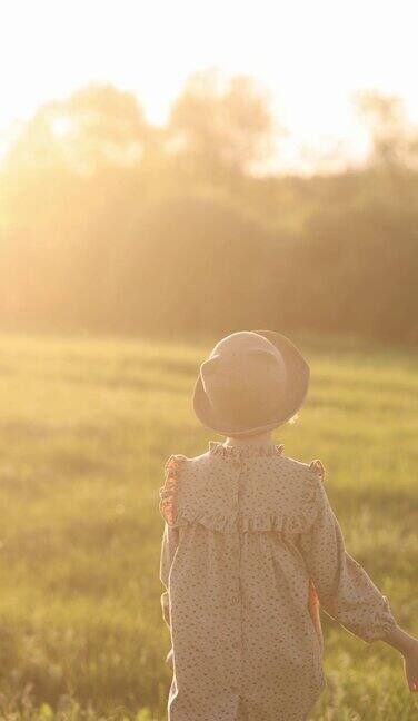 小女孩在夕阳下的草地上奔跑