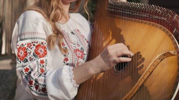 身穿刺绣衬衫的乌克兰女民间艺术家正在演奏班杜拉