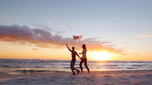 斯坦尼康慢动作镜头:年轻夫妇在日落的海滩上玩风筝