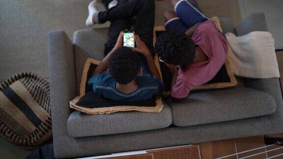 俯视图兄弟们在客厅用智能手机在家玩游戏