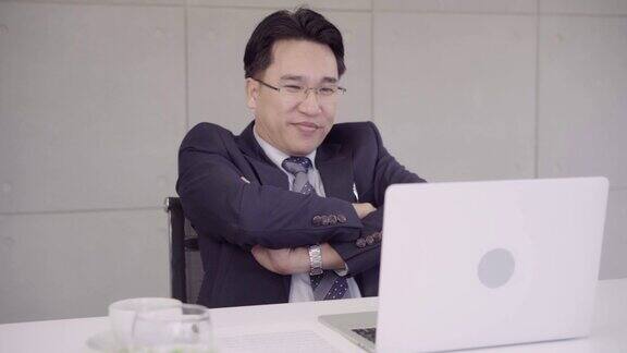 慢动作-成功的亚洲首席执行官商人穿着西装在办公室的办公桌上用笔记本电脑工作商人的工作理念