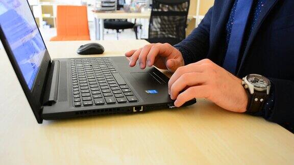 使用键盘的商人的手用手在笔记本电脑键盘上打字工作流