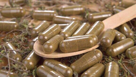 一堆药草和药丸里装着满满一木勺的药草胶囊