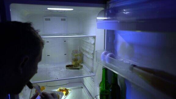 在冰箱里找食物的人那家伙吃了冰箱里剩下的食物拿了一瓶啤酒