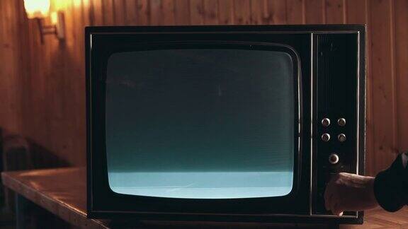 男人的手在旧电视上换频道有干扰的电器旧电视工作不好电视的噪音