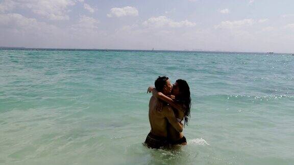 Сouple在海边亲吻拥抱男人和女人在暑假相爱