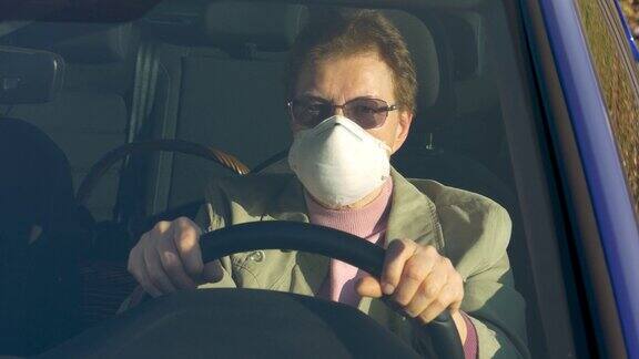 特写:在冠状病毒爆发期间老年妇女开车时戴口罩