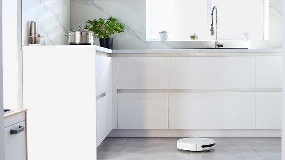 自动机器人吸尘器正在打扫厨房的地板公寓内自动电动清洁机器人清洁技术现代化的内部技术家里清洁4k的片段
