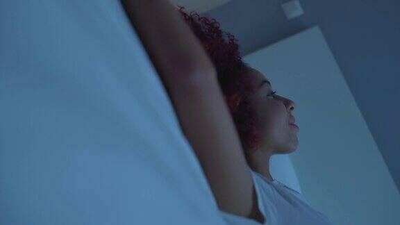 非裔美国女性躺在床上享受周末的休息舒适的卧室