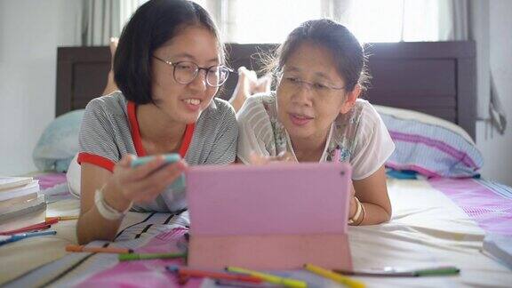 亚洲家庭使用数码平板电脑和智能手机在家里工作并通过网上购物来放松