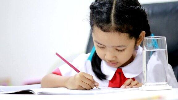亚洲小女孩在泰国幼儿园学生制服做作业近景