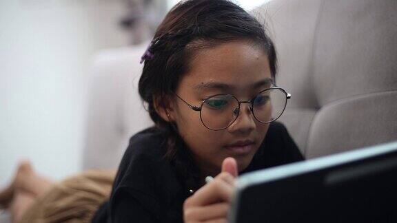 快乐女孩在家里用笔记本电脑在线学习英语