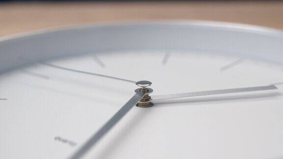 白色时钟的金属指针向前移动挂钟显示时间很快难以分辨的时间专注于手心