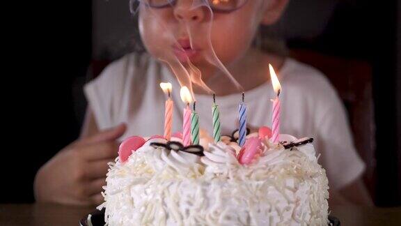 小女孩微笑着吹着生日庆祝甜甜的蛋糕