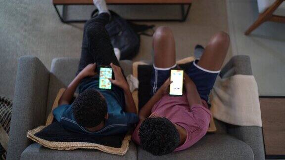 俯视图兄弟们在客厅用智能手机在家玩游戏