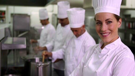 主厨对着镜头微笑身后是她的团队