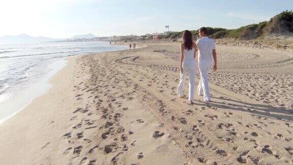 一对年轻夫妇在海滩上散步